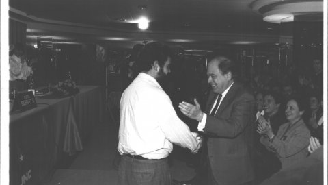 El president de la Generalitat i de Convergència Democràtica de Catalunya (CDC), Jordi Pujol, saluda el dirigent de la Joventut Nacionalista de Catalunya (JNC), Feliu Guillaumes, davant dels aplaudiments de Marta Ferrusola. 1991. Foto: Saül Gordillo