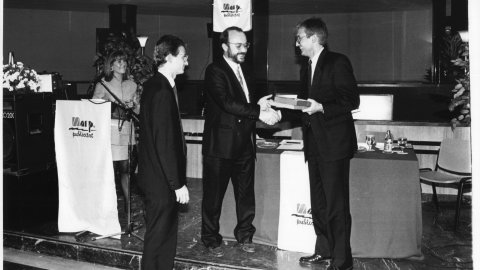 Josep Morell, de l'empresa Marp, acompanyat de Joan Morell, entrega un obsequi a Antoni Rossich, director de publicitat, en el marc de la Segona Nit de la Publicitat, presentada per Mari Pau Huguet. Santa Susanna. 1991. Foto: Saül Gordillo