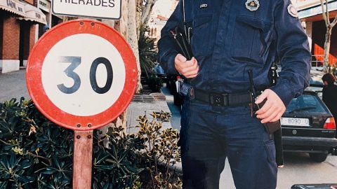 L'agent de la Policia Local Carles Montpeó, que va participar d'un intent de rescat heroic en una rierada de Canet de Mar, a la riera al costat d'un senyal que adverteix del perill de les rierades. Revista Repòrter de l'Alt Maresme. Anys 90. Foto: Saül Gordillo (Repòrter)