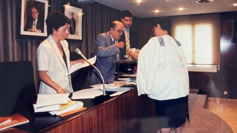 Constitució del Consell Comarcal del Maresme. L'alcalde de Canet de Mar, Josep Rovira (CiU), i el regidor del PP de Mataró Joan López, amb la secretària Mercè Mena, a la mesa, mentre vota l'alcaldessa de Malgrat de Mar, Conxita Campoy (PSC). Anys 90.