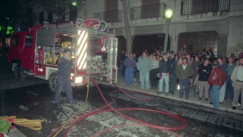Incendi a la botiga Mami-Kinder de la Riera de Mataró, amb els bombers apagant el foc. El regidor de la Policia Local, Remigi Herrero (PSC), i el de CiU Jordi Surinyach assisteixen al lloc dels fets. Mataró. 24 d'abril de 1996. Foto: Saül Gordillo (El Punt)