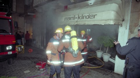 Incendi a la botiga Mami-Kinder de la Riera de Mataró, amb els bombers apagant el foc. El regidor de la Policia Local, Remigi Herrero (PSC), i el de CiU Jordi Surinyach assisteixen al lloc dels fets. Mataró. 24 d'abril de 1996. Foto: Saül Gordillo (El Punt)