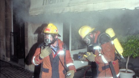 Incendi a la botiga Mami-Kinder de la Riera de Mataró, amb els bombers apagant el foc. El regidor de la Policia Local, Remigi Herrero (PSC), i el de CiU Jordi Surinyach assisteixen al lloc dels fets. Mataró. 24 d'abril de 1996. Foto: Saül Gordillo (El Punt)
