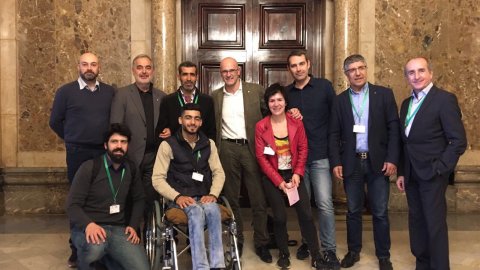El conseller d'Afers Exteriors de la Generalitat, Raül Romeva, i el director de Catalunya Ràdio, Saül Gordillo, reben al Parlament Adnan Faramanli, un noi sirià, de 19 anys, que corre maratons, però a qui una bala perduda el va deixar en cadira de rodes, i que ha vingut a Barcelona a córrer la Marató gràcies al programa 'Catalunya migdia' d'Òscar Fernàndez i Empar Moliner. 9 de març de 2017