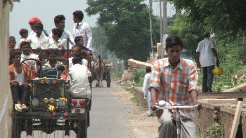 'Autopista' de Delhi cap a Jaipur, amb un vehicle ben carregat de gent, bicicleta en primer terme i camell en tercer terme. Agost 2007